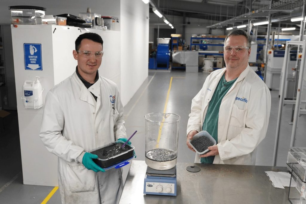 Jack Reynolds and Jon Elvins in a lab holding a box of alginate beads, which are a thermochemical energy storage material.
