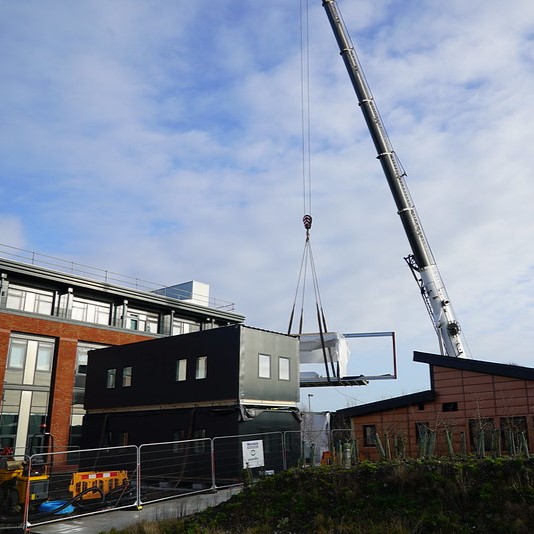 A crane lowering the modules of the Active Office into place. 
